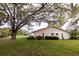 Large backyard with mature tree, green lawn and view of neighborhood homes at 4018 Oakhurst Dr # 3181, Sarasota, FL 34233