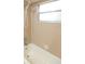 Neutral toned tiling surrounds a standard bathtub and shower fixture at 4018 Oakhurst Dr # 3181, Sarasota, FL 34233