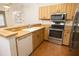The kitchen has wood cabinets, stainless steel appliances, and updated flooring at 4018 Oakhurst Dr # 3181, Sarasota, FL 34233