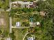 Overhead shot of the property showing the house, outbuildings, surrounded by lush greenery and mature trees at 4116 34Th E Ave, Bradenton, FL 34208
