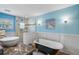Charming bathroom with a clawfoot tub, glass shower, blue walls, and elegant fixtures at 4116 34Th E Ave, Bradenton, FL 34208
