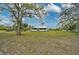 View of the home from a large yard with mature trees, bushes and foliage at 4116 34Th E Ave, Bradenton, FL 34208