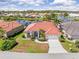 Aerial view of a single-Gathering home with red tile roof near a lake and lush landscaping at 4173 Hearthstone Dr, Sarasota, FL 34238