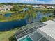 Aerial view of a screened-in pool, a lake, and lush landscaping at 4173 Hearthstone Dr, Sarasota, FL 34238