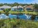 Aerial view of a backyard with a screened-in pool overlooking a serene lake at 4173 Hearthstone Dr, Sarasota, FL 34238
