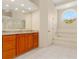 Bathroom with walk-in shower, granite top vanity, soaking tub, and bright circular window at 4173 Hearthstone Dr, Sarasota, FL 34238
