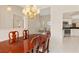Elegant dining room featuring a stunning chandelier and seamless transition to a modern, bright kitchen at 4173 Hearthstone Dr, Sarasota, FL 34238