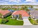 Beautiful waterfront home with lush landscaping, a tile roof, and a lovely circular window on a sunny day at 4173 Hearthstone Dr, Sarasota, FL 34238