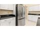Bright kitchen featuring white cabinetry, stainless steel fridge, and elegant dark countertops at 4173 Hearthstone Dr, Sarasota, FL 34238