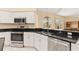 Modern kitchen with stainless steel appliances, dark countertops, and stylish white cabinets at 4173 Hearthstone Dr, Sarasota, FL 34238
