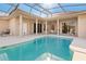 Backyard pool with a screened-in enclosure, patio, and an outdoor dining area at 4173 Hearthstone Dr, Sarasota, FL 34238