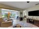Bright living room with tile floors leads to the screened lanai overlooking the backyard and water view at 4348 Bowling Green Cir # 9, Sarasota, FL 34233