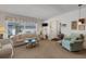 A cozy living room with natural light, a sofa, a swivel chair, and a glass coffee table at 4348 Bowling Green Cir # 9, Sarasota, FL 34233