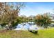 Picturesque backyard with a tranquil lake, lush greenery, and a kayak for enjoying the water at 4540 Murdock Ave, Sarasota, FL 34231