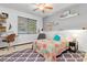 Cozy bedroom features ceiling fan, shelves, window and charming quilt bedding at 4540 Murdock Ave, Sarasota, FL 34231