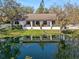 Charming home with a covered porch overlooking a serene pond, complemented by mature trees and landscaping at 4540 Murdock Ave, Sarasota, FL 34231