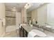Bathroom featuring granite counters, dual sinks, decorative mirrors, and tub shower combination at 4789 Vasca Dr, Sarasota, FL 34240