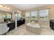 Bright bathroom with double vanity, garden tub, tile flooring, and natural light at 4789 Vasca Dr, Sarasota, FL 34240