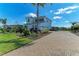 Elegant two-story residence featuring a brick-paved driveway, lush landscaping, and attached three-car garage at 4789 Vasca Dr, Sarasota, FL 34240