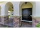 Inviting front entrance with double doors, stone pillars, and brick-paved porch at 4789 Vasca Dr, Sarasota, FL 34240