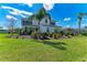 Beautiful two-story home with lush green lawn, elegant landscaping, and swaying palm trees at 4789 Vasca Dr, Sarasota, FL 34240