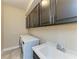 A functional laundry room featuring a washer, dryer, sink and built in shelving at 4789 Vasca Dr, Sarasota, FL 34240