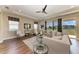 Bright living room features tray ceiling, ceiling fan, and sliding glass doors to the backyard at 4789 Vasca Dr, Sarasota, FL 34240