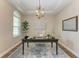 Stylish home office featuring a dark wood desk, elegant chandelier, and tray ceiling at 4789 Vasca Dr, Sarasota, FL 34240
