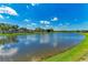 Scenic pond view with blue skies and lush green grass, offering a tranquil and serene environment at 4789 Vasca Dr, Sarasota, FL 34240