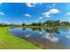A beautiful view of the pond with blue skies and lush greenery, giving the home a peaceful and picturesque backdrop at 4789 Vasca Dr, Sarasota, FL 34240