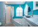 Bright bathroom with turquoise walls, vessel sink, glass shower and corner tub at 5110 76Th E St, Bradenton, FL 34203