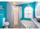 Bright bathroom with turquoise walls, glass shower and corner tub at 5110 76Th E St, Bradenton, FL 34203