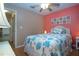 Coastal themed bedroom with coral accent wall, ceiling fan, and wicker nightstand at 5110 76Th E St, Bradenton, FL 34203