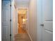 Hallway with wood floors, white trim, and view into a warmly lit bedroom at 5110 76Th E St, Bradenton, FL 34203
