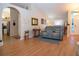Open concept living room with vaulted ceilings, hardwood floors, and comfortable gray reclining love seat at 5110 76Th E St, Bradenton, FL 34203