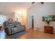 Spacious living room with vaulted ceilings, hardwood floors, and comfortable gray reclining love seat at 5110 76Th E St, Bradenton, FL 34203