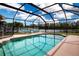 Sparkling screened-in pool with lounge chairs and serene views of the lake beyond at 5110 76Th E St, Bradenton, FL 34203