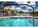 Relax by the sparkling screened-in pool featuring plenty of lounge chairs and an umbrella at 5110 76Th E St, Bradenton, FL 34203