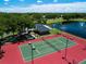 Aerial view of the community tennis court with adjacent lake and clubhouse at 5110 76Th E St, Bradenton, FL 34203