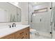 Bright bathroom featuring a glass enclosed shower, wood vanity, and modern fixtures at 5142 Cote Du Rhone Way, Sarasota, FL 34238