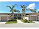 Inviting condo exterior featuring palm trees, attached garages, and well-maintained landscaping at 5250 Hyland Hills Ave # 1514, Sarasota, FL 34241