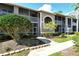 A beautiful exterior view of the condos showing screened lanais and mature landscaping at 5250 Hyland Hills Ave # 1514, Sarasota, FL 34241
