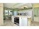 Open kitchen features white cabinetry and island, appliances, and an adjacent dinette area with picturesque lake views at 5250 Hyland Hills Ave # 1514, Sarasota, FL 34241