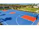 A high-angle shot of a well-maintained basketball court with bright blue surfacing and colorful key areas at 5317 Coral Reef Way, Bradenton, FL 34211