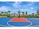 Outdoor basketball court featuring vibrant blue and red colors against a backdrop of palm trees and sunny skies at 5317 Coral Reef Way, Bradenton, FL 34211