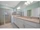 Contemporary bathroom featuring double sinks, a large mirror, and a glass-enclosed shower at 5317 Coral Reef Way, Bradenton, FL 34211