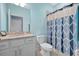 Stylish bathroom showcasing a granite vanity, toilet, and shower with a patterned blue and white curtain at 5317 Coral Reef Way, Bradenton, FL 34211