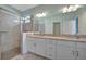 Elegant bathroom featuring double sinks, a large mirror, and a walk-in shower with modern fixtures at 5317 Coral Reef Way, Bradenton, FL 34211