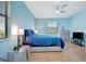 This bedroom features bright blue walls, a ceiling fan and an updated dresser and entertainment center at 5317 Coral Reef Way, Bradenton, FL 34211