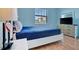 Comfortable bedroom featuring a blue color scheme, wood floors, and natural light from the window at 5317 Coral Reef Way, Bradenton, FL 34211